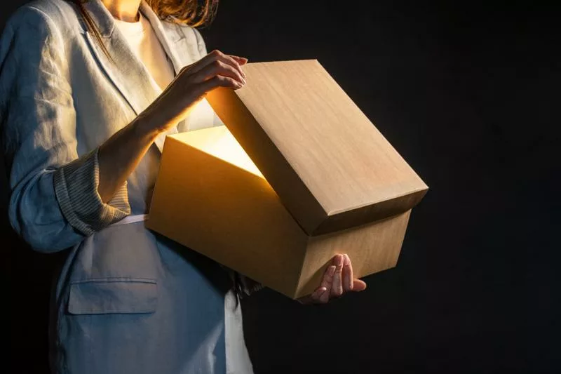 Woman opening glowing box symbolizing the power of promotional marketing