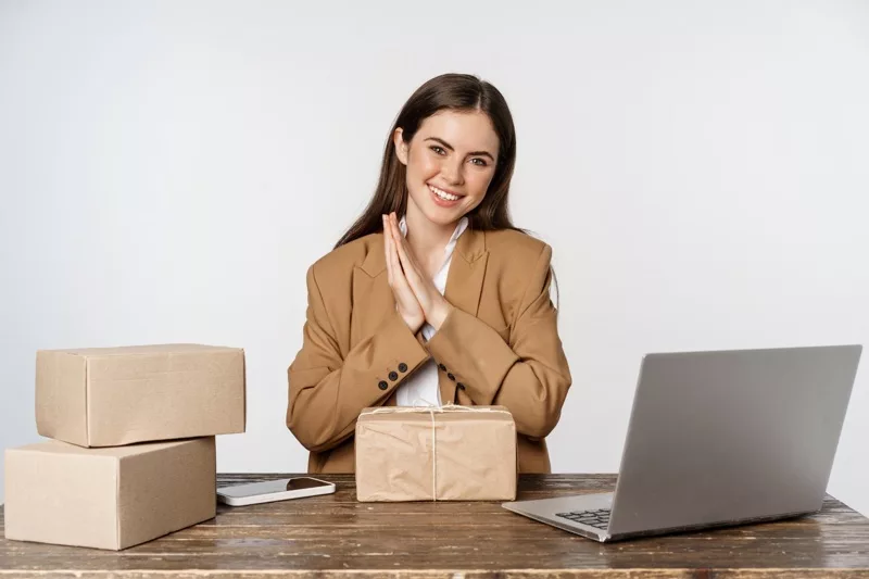 Person smiling with shipped gift boxes while working remotely.