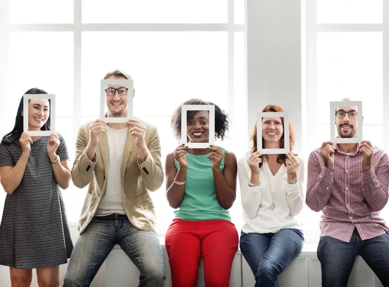 Group of people posing with photo frames at booth activation