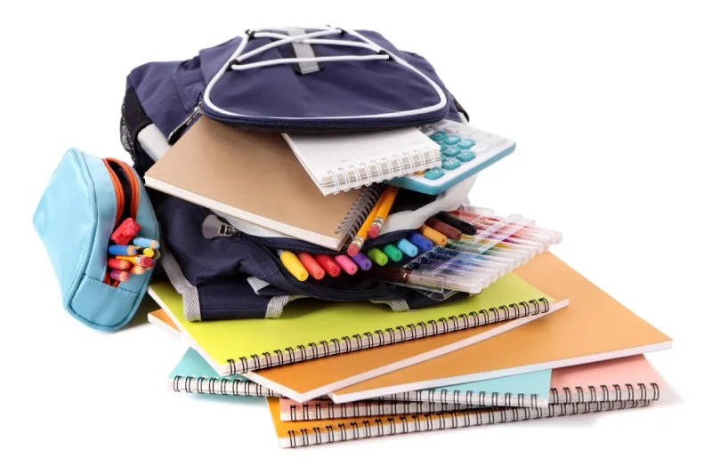 Backpack overflowing with spiral notebooks, pens, and calculators