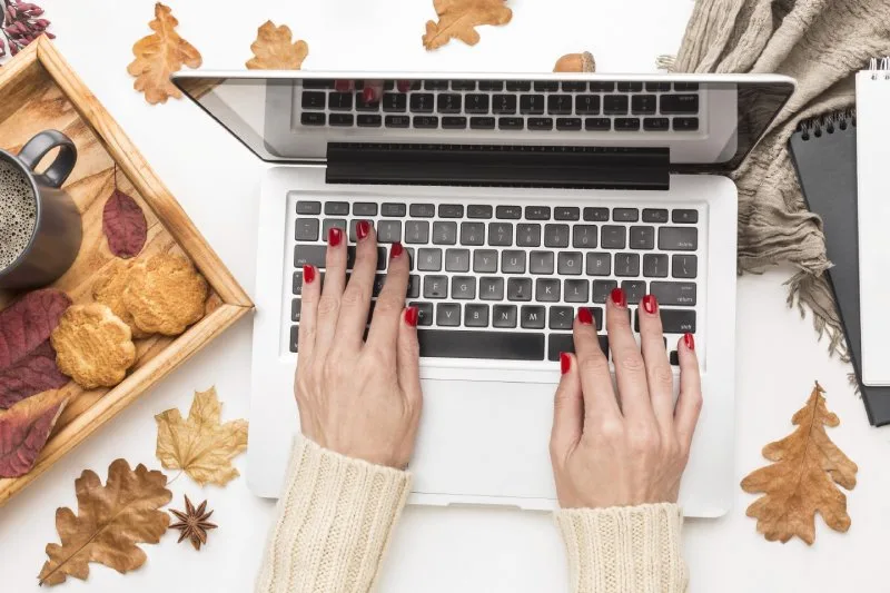 Successful fall giveaway planning concept with laptop, coffee, cookies, and autumn leaves for seasonal branding