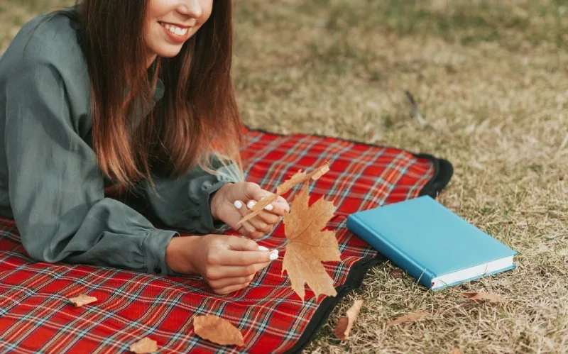 Fall outdoor giveaway idea showing autumn picnic with plaid blanket and journal for branded seasonal fun.