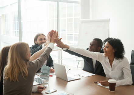 Team High Five at Conference Room Table