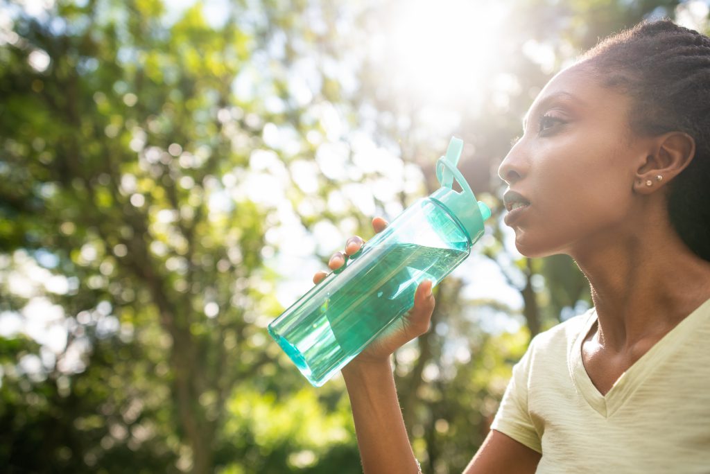 A woman outside with a plastic water bottle