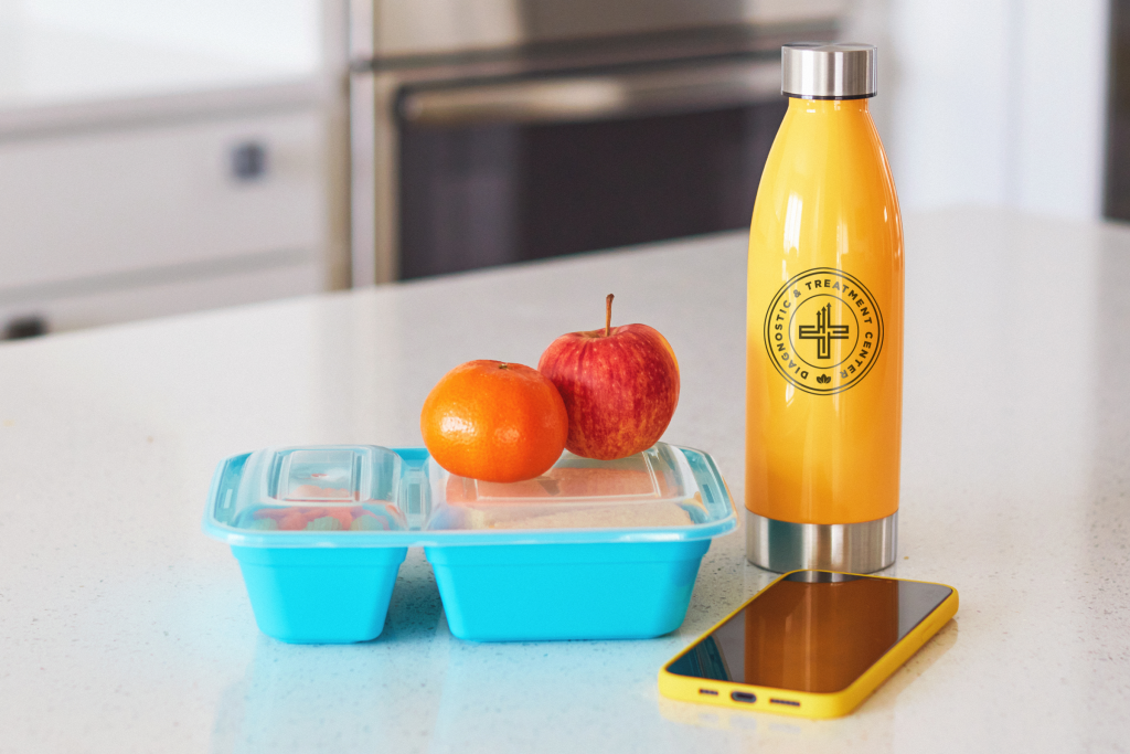Branded water bottle on counter with healthy lunch