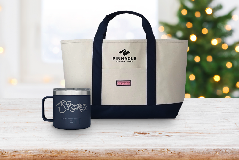 Blue YETI coffee mug with white Vineyard Vines tote bag in front of Christmas tree.