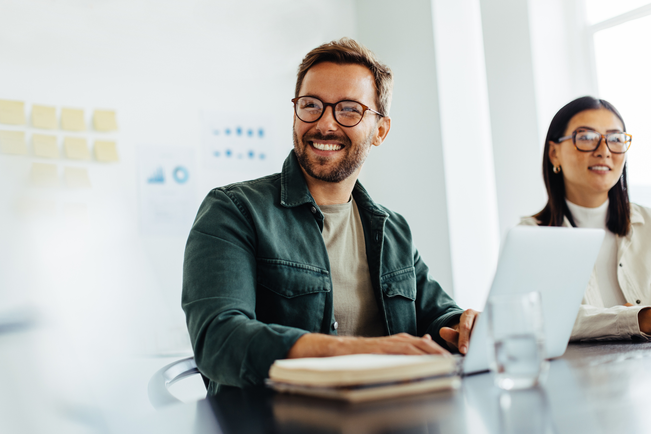 Man and woman smiling in tech meeting