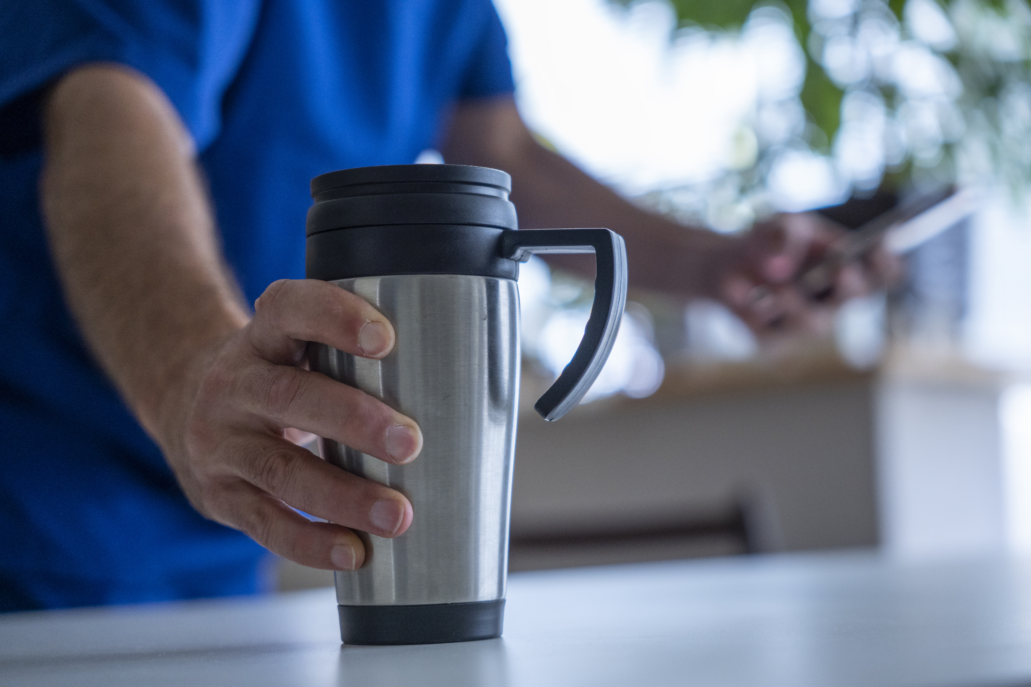 Doctor holding branded travel mug