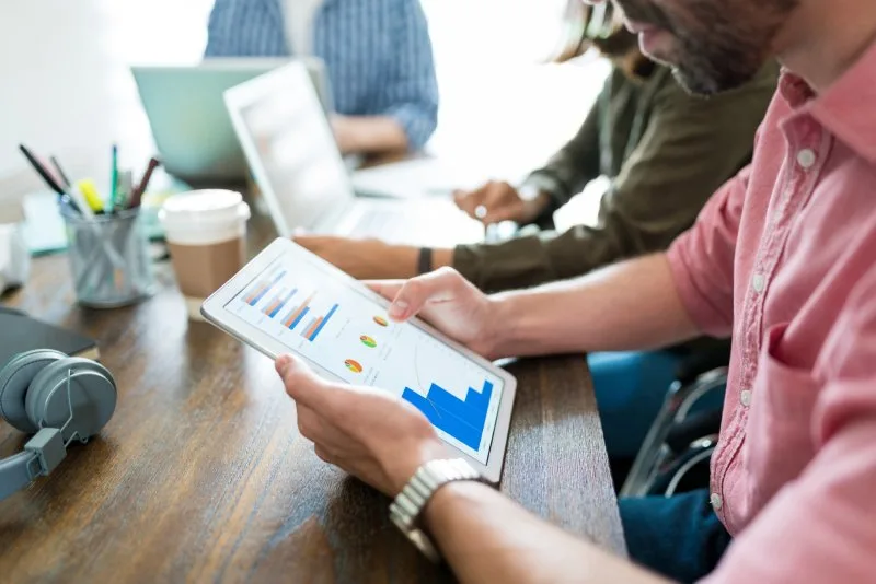 Team reviewing trade show performance data and analytics on tablet to track lead generation results.