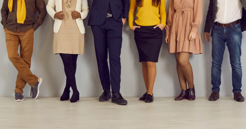 Waist-down image of an office team in workwear apparel, standing against a wall