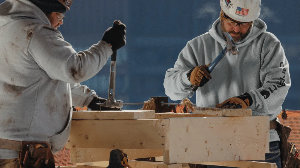 Men wearing custom Carhartt hoodie in gray while working construction.