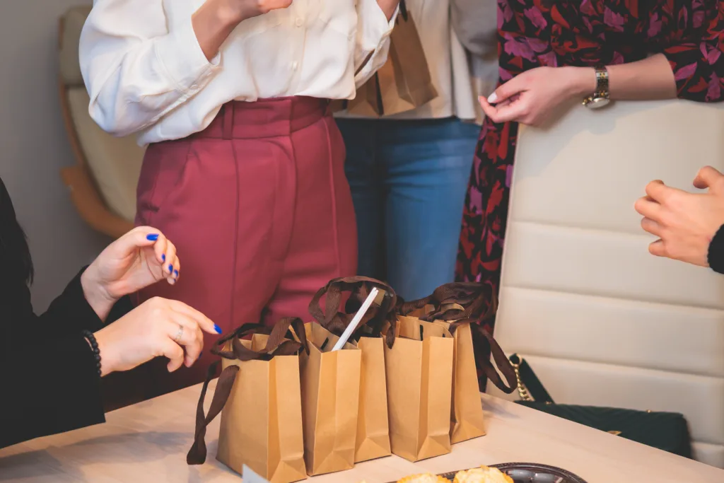 Employee appreciation gifts lined up on desk with the team gathered around