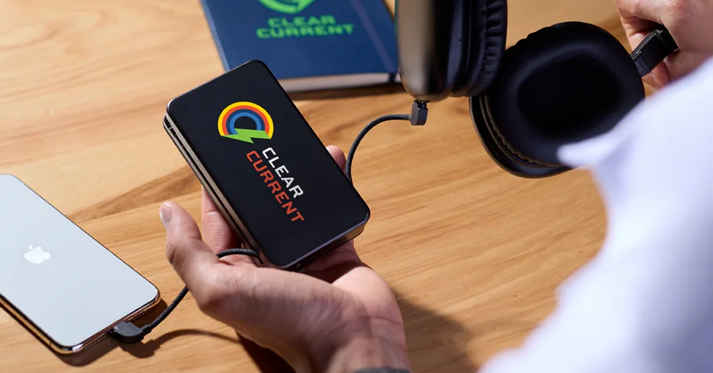 Person's hand holding branded wireless charger