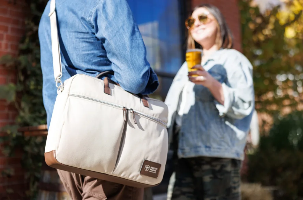 Man and woman talking as man holds laptop bag given as a corporate anniversary gift