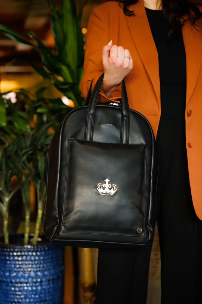 Woman's arm holding black purse given as work anniversary gift