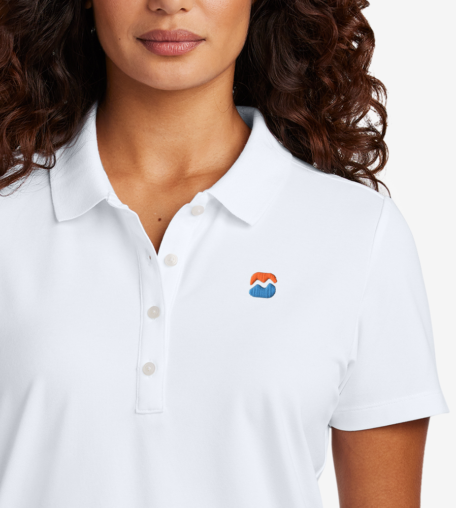 Woman wearing a white polo shirt with an embroidered logo on the left chest