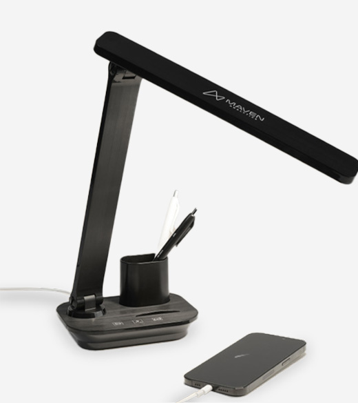 black LED desk lamp featuring the logo on the arm, integrated with a pen holder and a base that is charging a smartphone