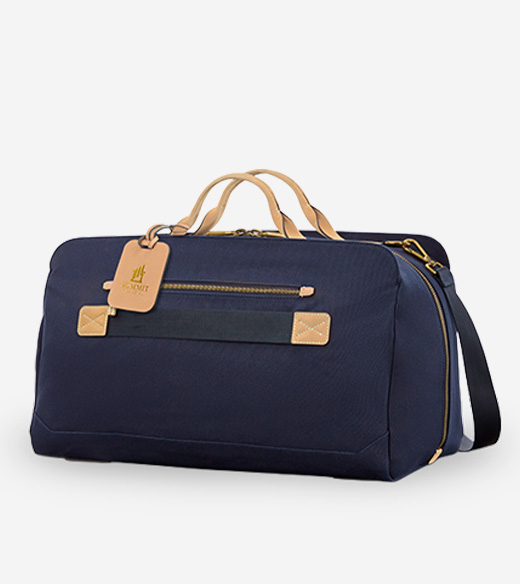 high-quality navy blue canvas duffle bag with tan leather handles and accents